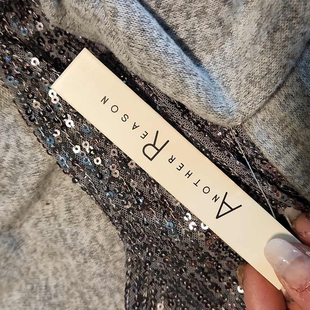 Light grey Vneck loose fitting sweater, with sequins on a flared sleeve with c